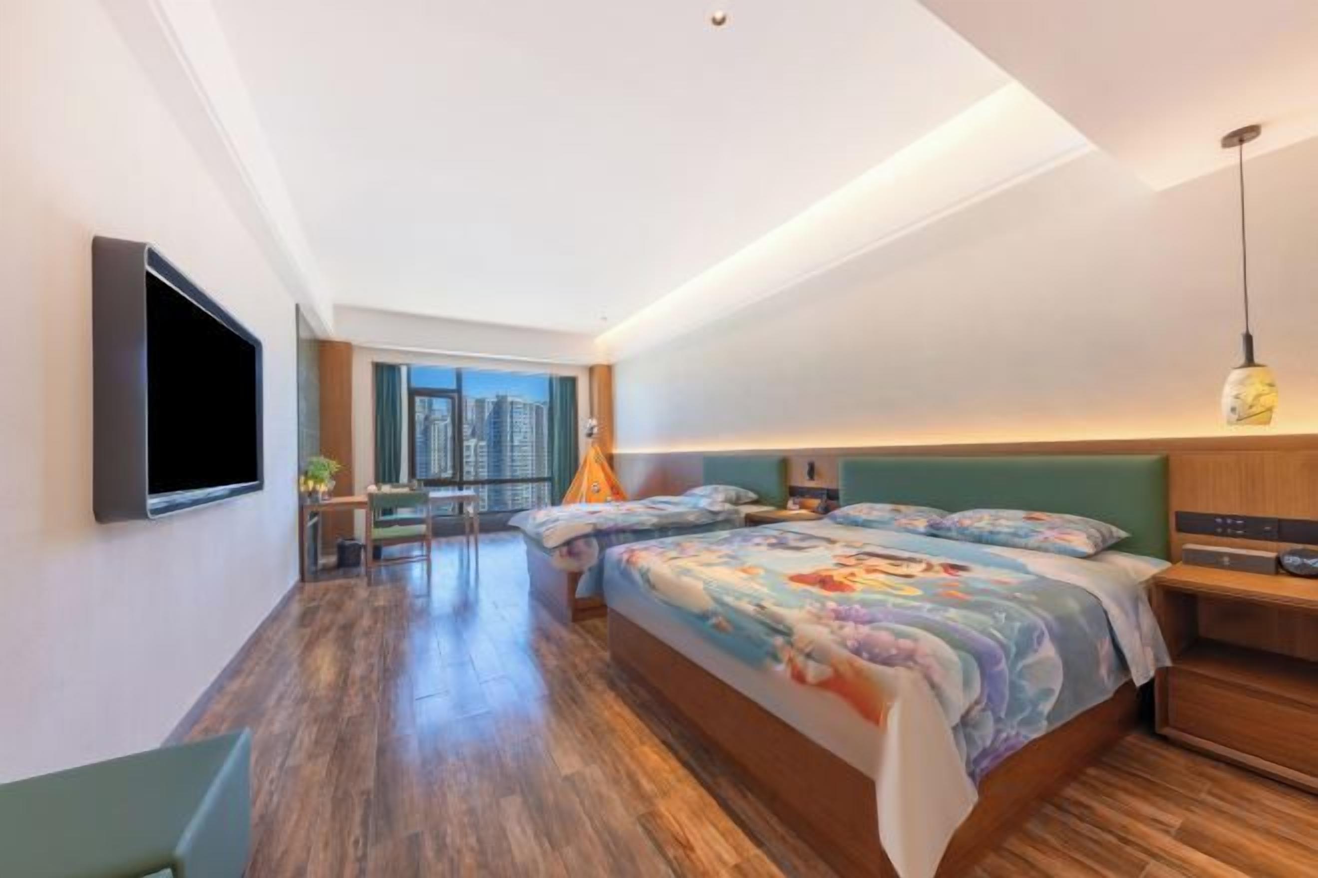A modern hotel room with a large bed, a desk, and a TV.