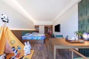 A hotel room with a bed, a desk, a television, and a tent with plush toys. - Dehua Meiyuan International Hotel (Hongqifang Ceramic Tourism Store) (Dehua)