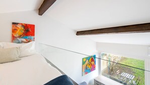 A bedroom with a bed, a glass balcony, and two paintings on the wall. - VIVA Casinha da Foz - Close to the beach (Porto)