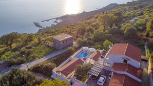 A coastal property with a swimming pool, terraced roofs, and a view of the sea. - Beach front home in Jesenice (Jesenice)