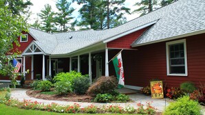 A red building with a porch, an American flag, and a welcome sign. - Garth Newell Waterfront -  Kayaks, canoes, water trampoline, fire pit, swimming (Maryland)