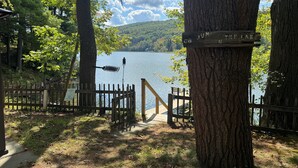 A wooden deck leading to a lake with a sign reading "JUMF THE LAKE". - Garth Newell Waterfront -  Kayaks, canoes, water trampoline, fire pit, swimming (Maryland)