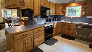 Eine Küche mit Holzausstattung, Mikrowelle, Herd und Geschirrspüler.