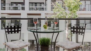 A modern outdoor dining area with a glass table, two cushioned chairs, and two wine glasses. - Awesome Location for 5th AVE & BEACH access without  noise! INCREDIBLE ROOFTOP (Playa Del Carmen, Solidaridad)