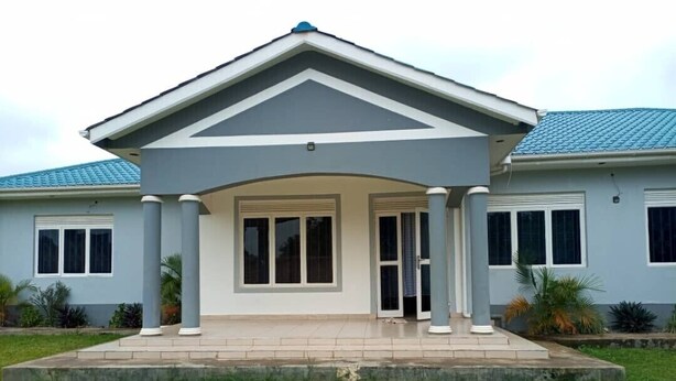 Une maison à deux étages dotée d’un porche avant couvert, d’un toit en tuiles et d’une pelouse bien entretenue.