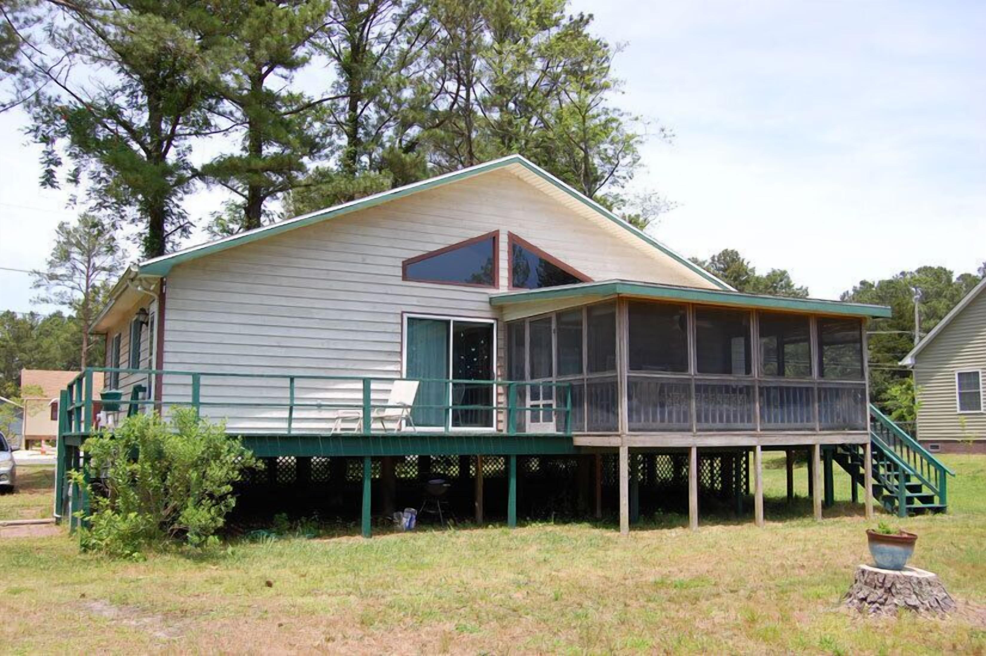 A two-story house with a covered porch and a screened area.