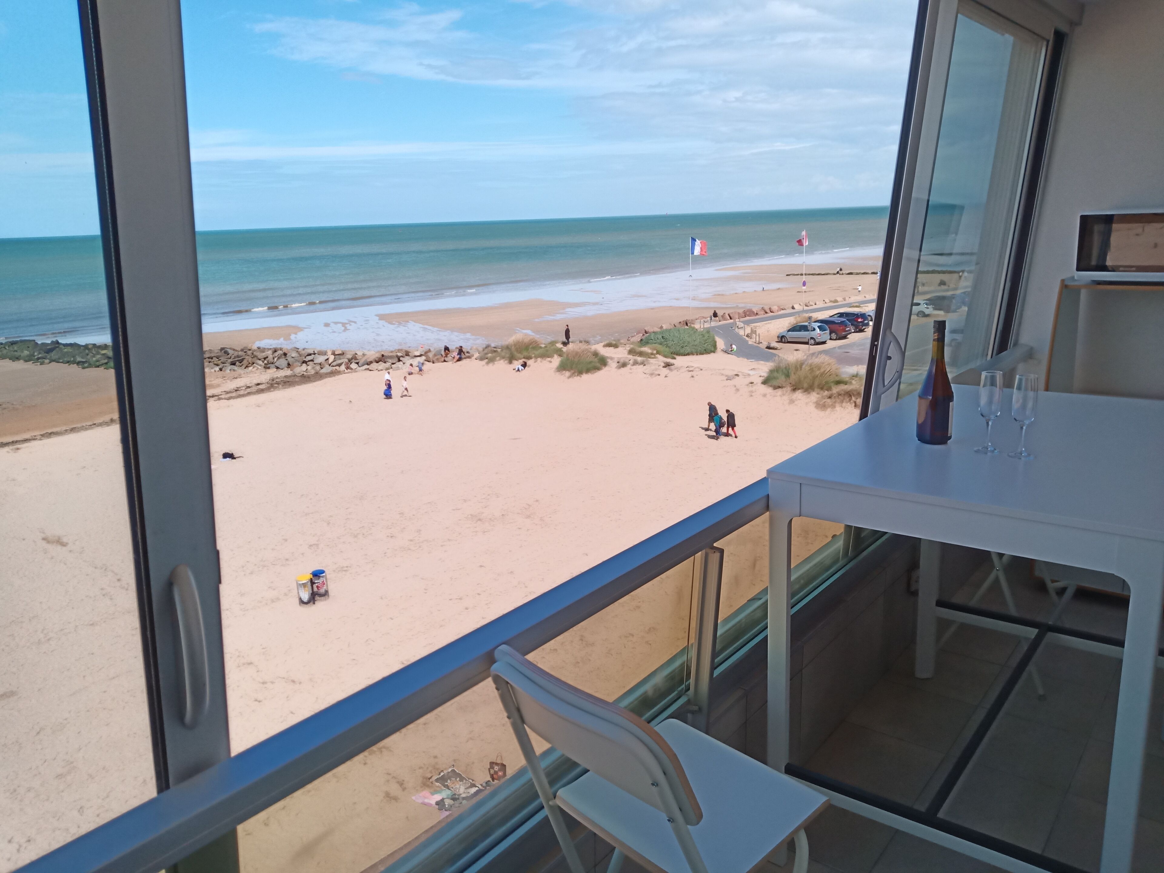 Ein Balkon mit Blick auf einen Sandstrand und das Meer.
