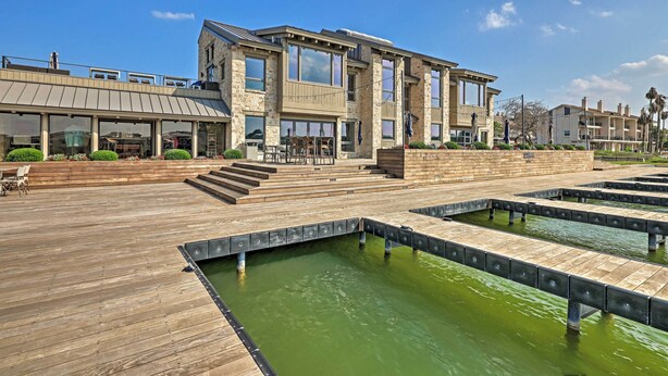 A modern building with a wooden deck and a water feature. - Modern Townhome w/ Patio, Next Door to Resort (Horseshoe Bay)