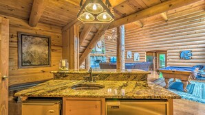 Ein Holzblock-Interieur mit Küchenbereich, ausgestattet mit Granitarbeitsplatten, einem Spülbecken und einem Geschirrspüler.