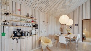 A cozy dining area with a wooden table, chairs, and a hanging light fixture.