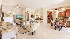 A spacious living room with a sofa, armchairs, and a dining area with a table and chairs. - LUXURY HOUSE BY THE CANAL ☀️ (Siesta Key)