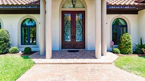 A house with a tiled roof, a central entrance with a double door, and a small porch area. - LUXURY HOUSE BY THE CANAL ☀️ (Siesta Key)