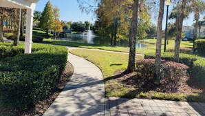 A park pathway with a fountain, surrounded by well-maintained hedges and trees. - Cozy ❤️ Beach Style Condo near Disney & Universal (Kissimmee)