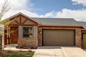 A residential house with a stone facade, a wooden front door, and a garage. - Luxury Home in Great Location, Hot Tub + Patio, Family/Theater Room! (Heber City)