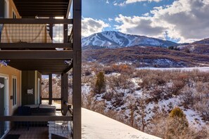 A multi-level building with a balcony overlooking a snowy landscape and mountains. - Free Ski Shuttle, Hot Tub + Patio, Family/Theater Room! (Heber City)
