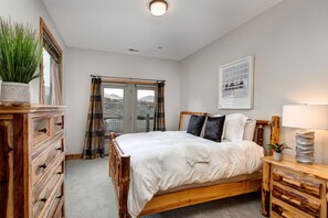 A bedroom with a wooden bed, a dresser, a nightstand, a potted plant, and a framed picture on the wall. - Luxury Home in Great Location, Hot Tub + Patio, Family/Theater Room! (Heber City)