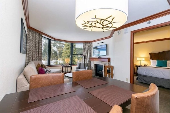 Relax in a spacious room with a dining area, fireplace, and comfortable seating for four.