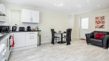 A compact living space with a kitchenette, dining area, and seating area.