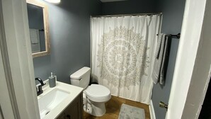 Een badkamer met toilet, wastafel en douchegordijn.