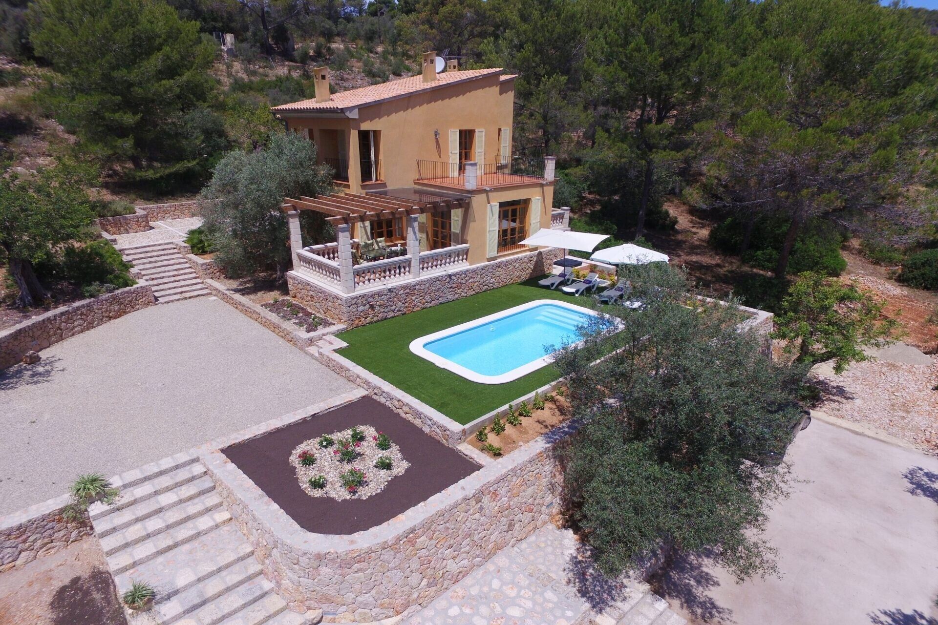 Une maison à deux étages avec une piscine, des marches en pierre et un jardin.