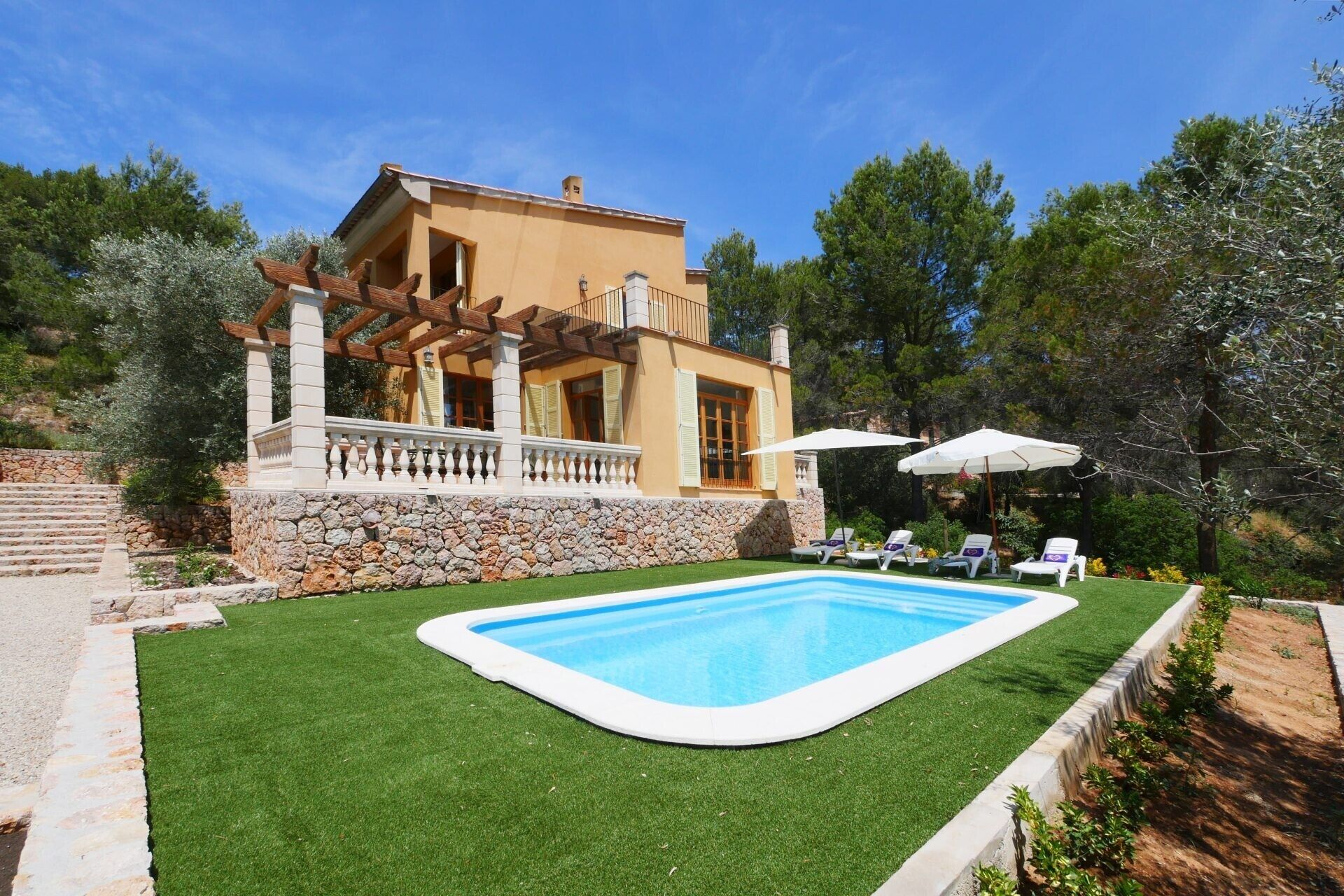 A house with a swimming pool, stone steps, and a garden.