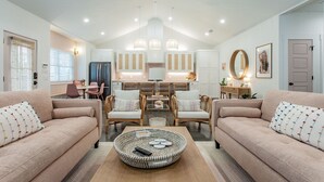 Ein modernes Wohnzimmer mit zwei Sofas, einem Couchtisch und einem Essbereich mit Stühlen und einem Tisch.