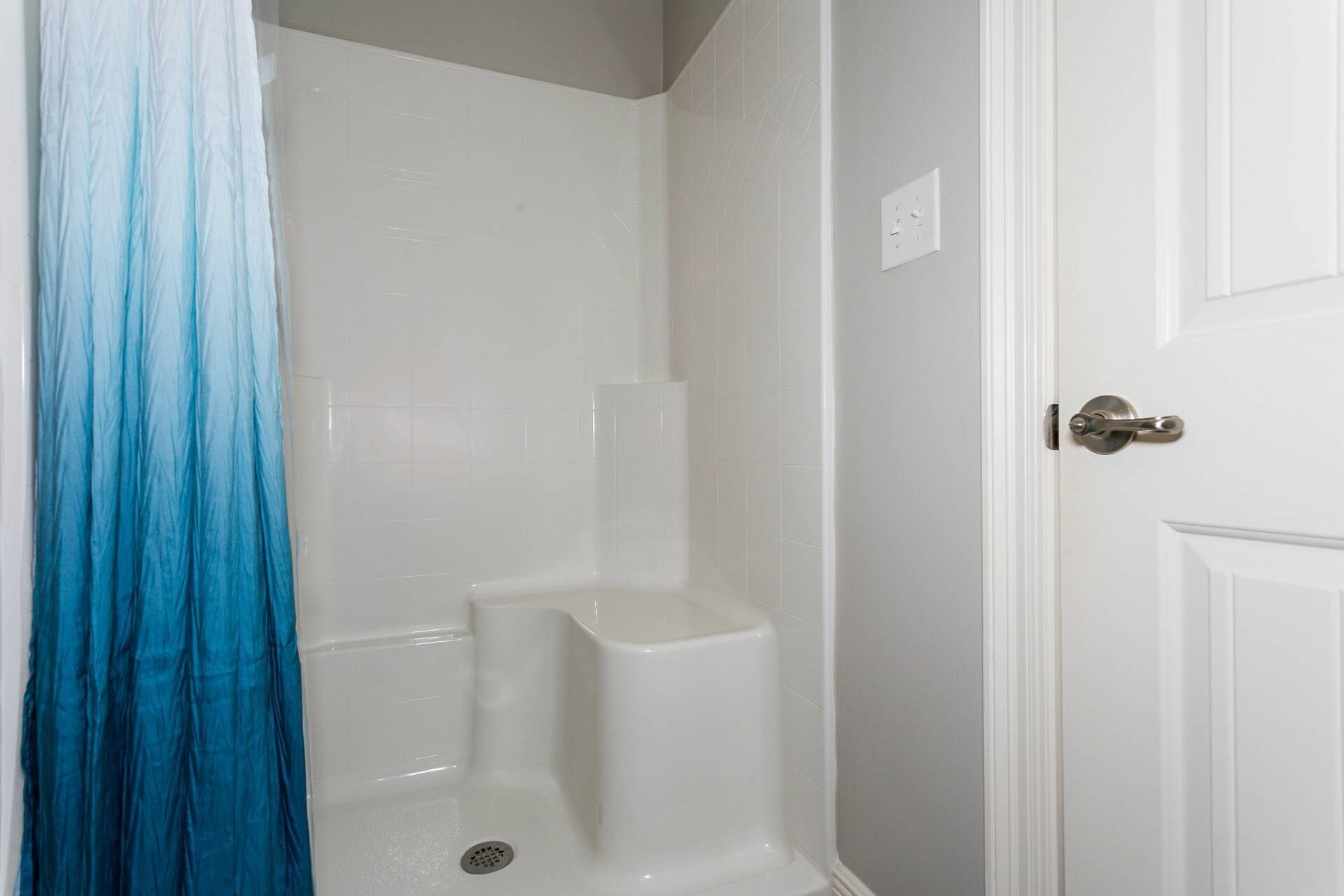 A bathroom with a shower curtain, a toilet, and a sink.