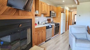 A modern kitchen with wooden cabinets, a stainless steel refrigerator, a microwave, a stove, and a dishwasher. - 2 bedroom 2 full baths, Outdoor heated pool, sleeps 6, Near LAKES, Schuss course (Mancelona)