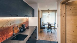 Una cocina moderna con un lavamanos, cafetera y armarios de madera.