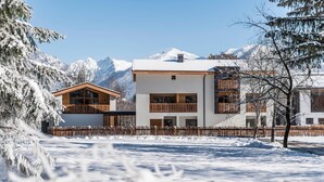 Un bâtiment moderne doté d’une façade en bois, de grandes fenêtres et d’un balcon.