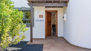 A building entrance with a wooden door, a sign reading 'Villa Marta,' and a small garden area with a cactus plant. - Villa "Marta" with Pool, Garden, and Terrace (Playa Blanca)