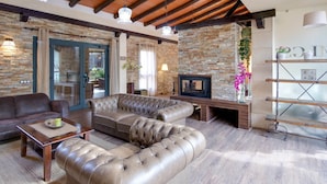 A living room with a sectional sofa, a coffee table, and a fireplace.