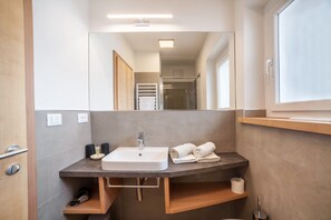 Une salle de bain moderne avec un lavabo, un porte-serviettes et un miroir.
