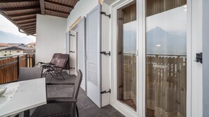 A balcony with a table and chairs, a view of mountains, and a sliding glass door. - Apartment "Haus Hohenrain 3" with Mountain View, Pool, Wi-Fi, Terrace & Garden (Schenna)