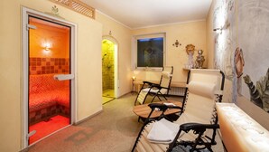 A spa room with a sauna, massage chairs, a small table, and a decorative wall. - Apartment "Haus Hohenrain 3" with Mountain View, Pool, Wi-Fi, Terrace & Garden (Schenna)