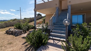 Un bâtiment à deux étages doté d’un balcon, d’un escalier et offrant une vue dégagée sur le paysage environnant.