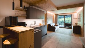Une cuisine moderne avec des poutres en bois, un îlot central et un coin repas offrant une vue agréable.