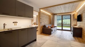 Una cocina moderna con gabinetes grises, un lavamanos de acero inoxidable y un techo de madera.