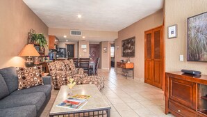 A living room with a sofa, coffee table, and a dining area with chairs and a table. - Princesa Resort D-307 Pelican's Post Ocean View Chic Condo (Puerto Peñasco)