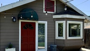 A single-story house with a red front door, a small porch, and a window with a white frame. - Citrus Cottage in Old Town Orange near Chapman U & Disneyland  (Orange)