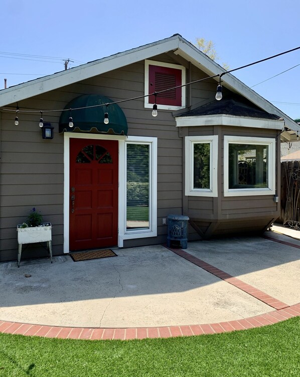 A single-story house with a red front door, a small porch, and a window with a white frame. - Citrus Cottage in Old Town Orange near Chapman U & Disneyland (Orange)