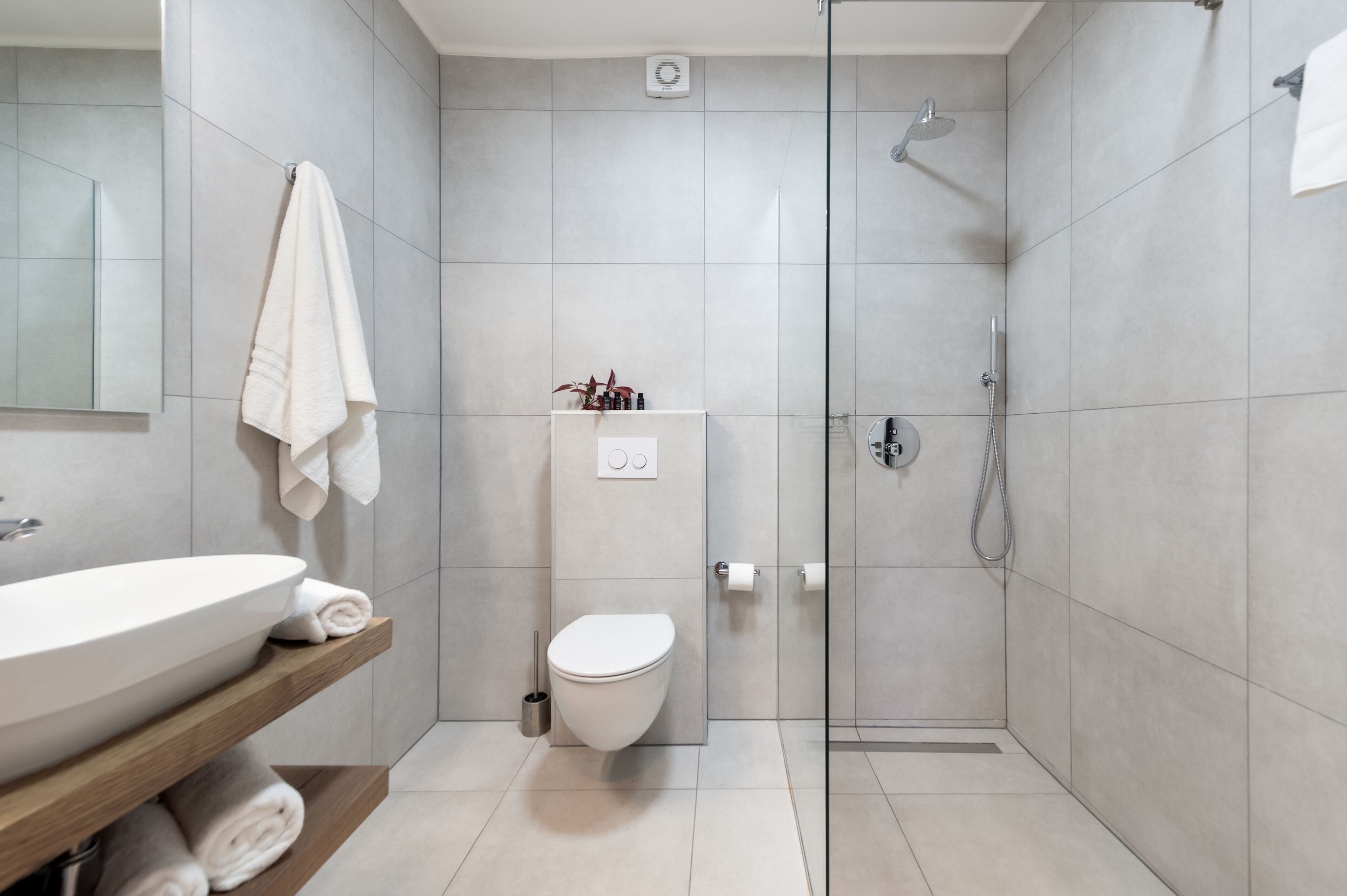 Ein modernes Badezimmer mit einem großen Waschbecken, Toilette und einer Duschkabine.