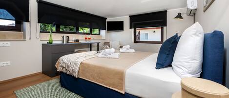 Quarto moderno com cama, mesa de cabeceira e vista para o exterior.
