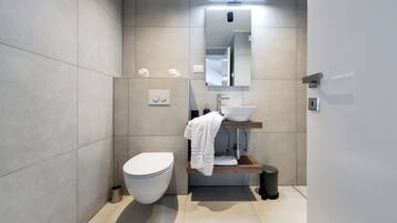 Un bagno moderno con servizi igienici, lavandino e specchio.