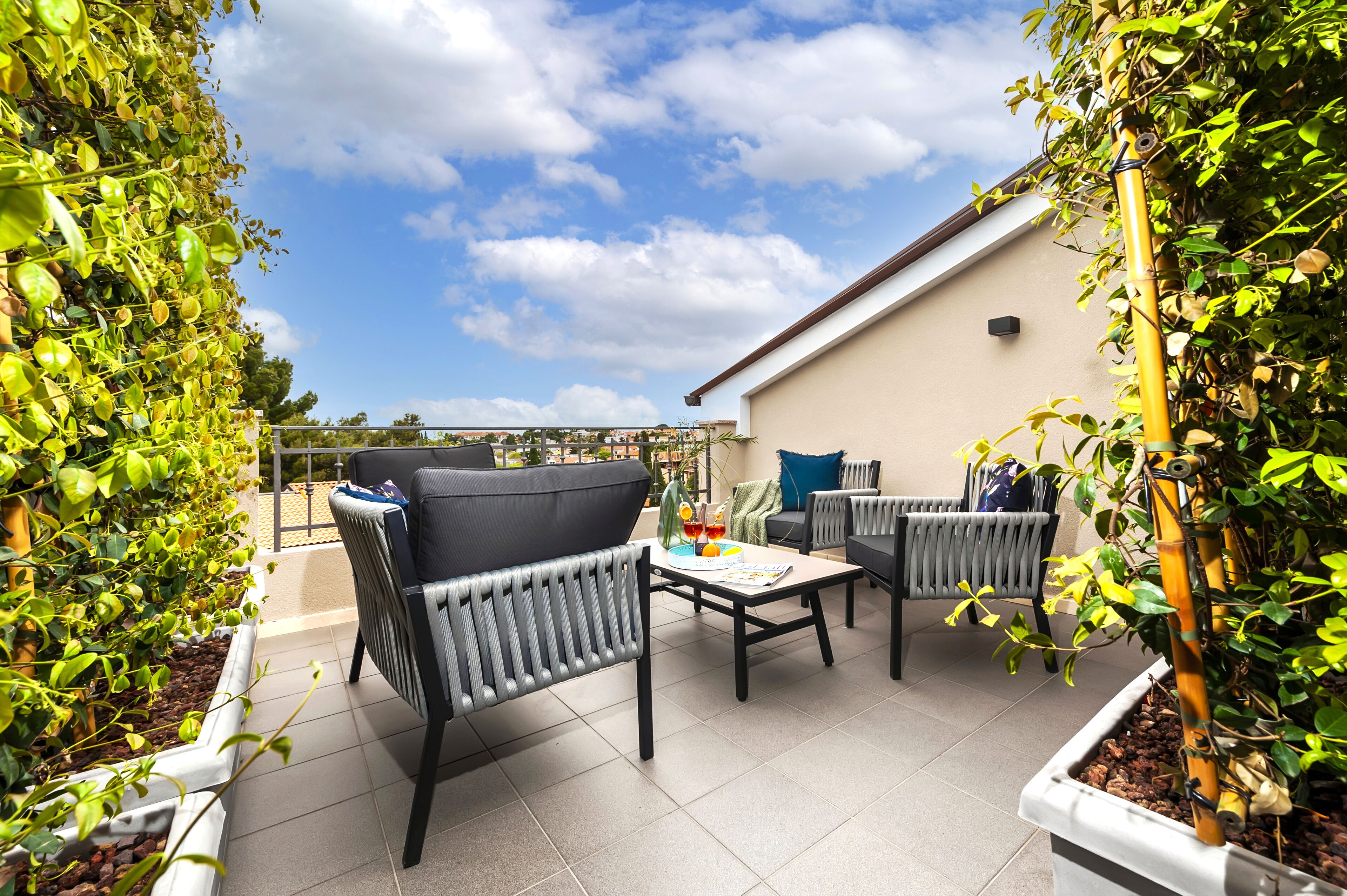 A patio area with outdoor furniture, a table, and potted plants.