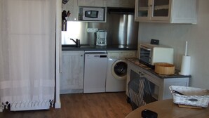 Cocina compacta con lavadora, microondas y tostadora.