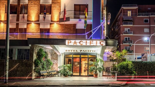 Exterior del Hotel Pacífico, con fachada de ladrillo, ventanas grandes y un cartel.