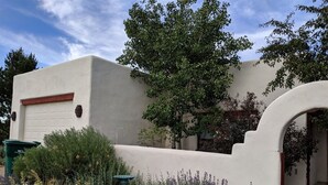 A building with a white exterior, a garage, and a stone pathway leading to an entrance.