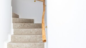 Eine Treppe mit einem hölzernen Geländer und einem runden, dekorativen Deckenornament.