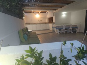 An indoor space with a dining area, kitchen, and seating area. - Casa Vacanze Baia Caddinas (Golfo Aranci)